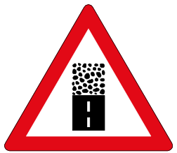 Gravel road begins sign